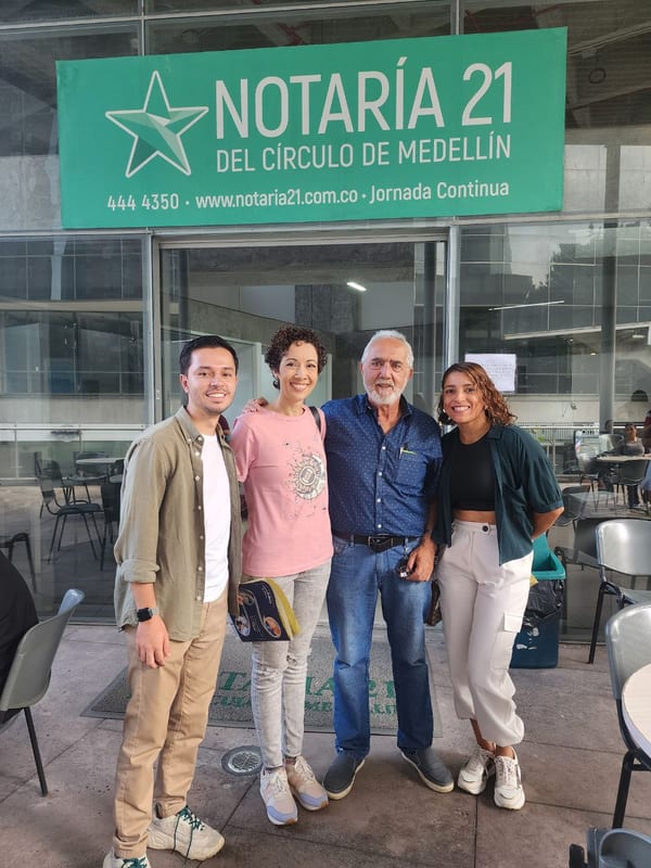 Cuatro personas posando frente a la Notaría 21 del Círculo de Medellín