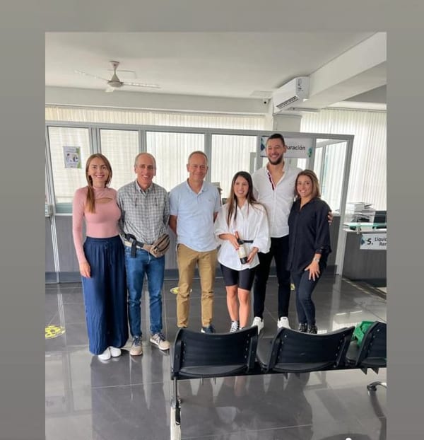 Grupo de seis personas posando en la sala de espera de una oficina